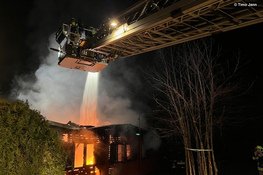 Feuerwehrleute löschen mithilfe einer Drehleiter