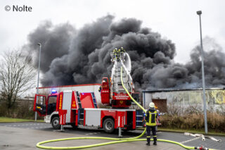 Mit einem massiven Löschangriff vom Boden und über die Drehleitern bringen die Einsatzkräfte das Feuer in einer Kfz-Werkstatt in Wees nach einer reichlichen Stunde unter Kontrolle. Foto: Nolte