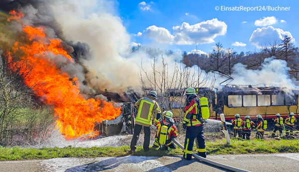 Ein Tanklaster kollidiert an einem unbeschrankten Bahnübergang bei Karlsruhe mit einer Stadtbahn. Beide Fahrzeuge gehen in Flammen auf. Feuerwehrleute bringen die Flammen mit Schaum unter Kontrolle. Foto: EinsatzReport24/Buchner